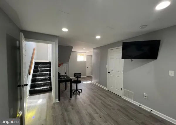 a view of a livingroom with entryway wooden floor chair and windows