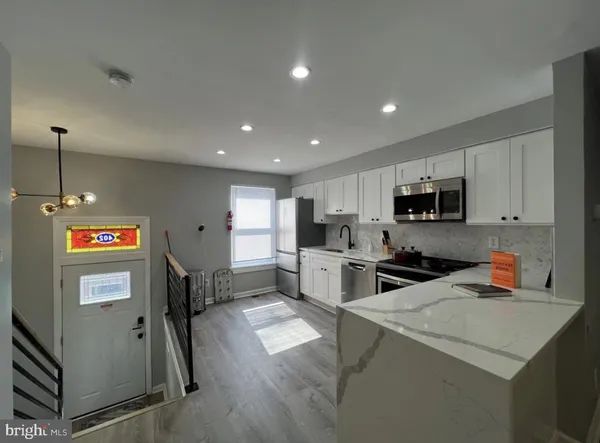a kitchen that has a lot of cabinets a sink and appliances