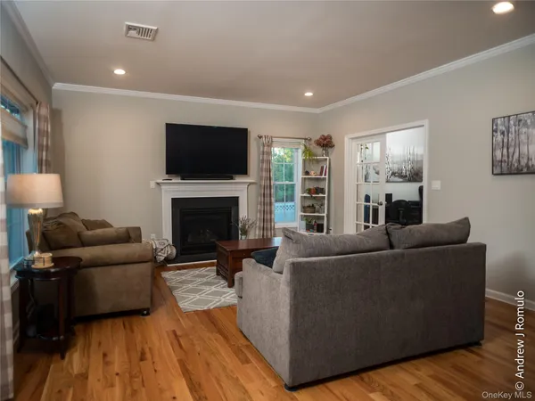 a living room with furniture a flat screen tv and a fireplace