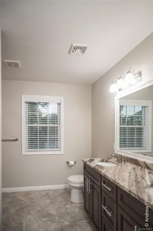 a spacious bathroom with a granite countertop tub a sink and a large window