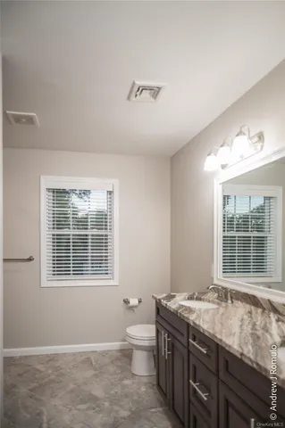 a spacious bathroom with a granite countertop tub a sink and a large window