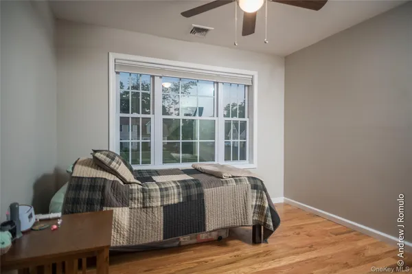 a spacious bedroom with a bed and wooden floor