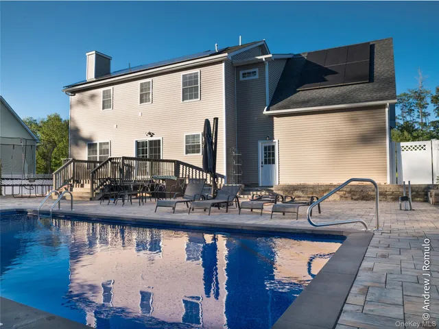a front view of house with yard outdoor seating and lake view