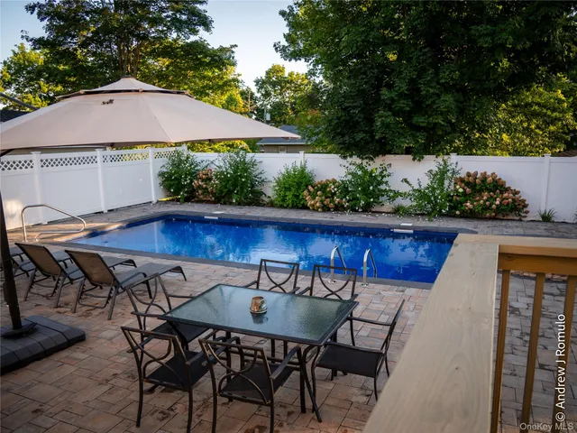 a view of patio with table and chairs under an umbrella