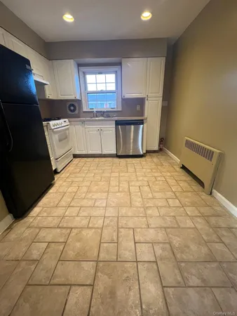 a kitchen with granite countertop a sink a stove a microwave and cabinets
