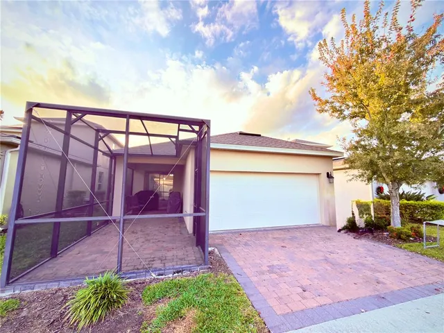 a view of a house with a yard and a large tree