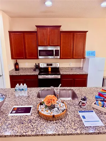 a kitchen with stainless steel appliances granite countertop a stove a sink and a microwave