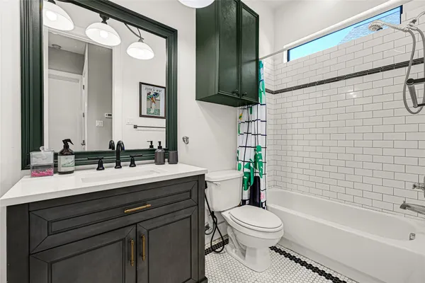 a bathroom with a granite countertop sink toilet a large mirror a bathtub and shower