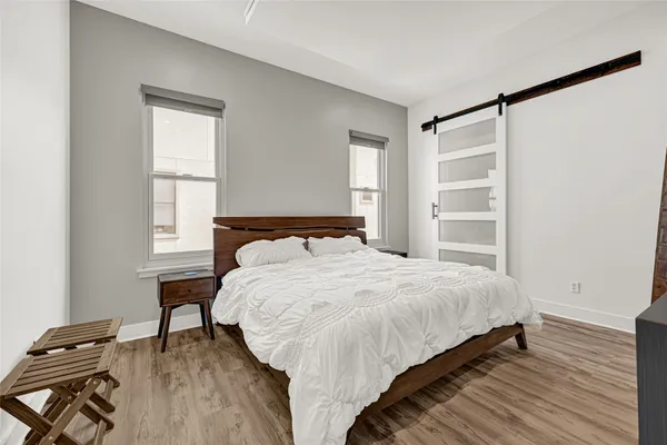 a bedroom with a bed and wooden floor