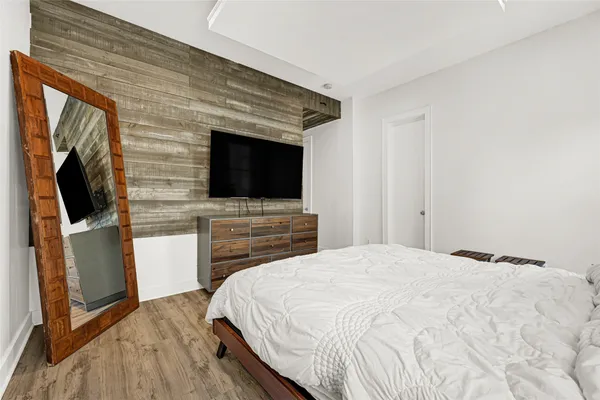 a bedroom with a bed and a flat screen tv