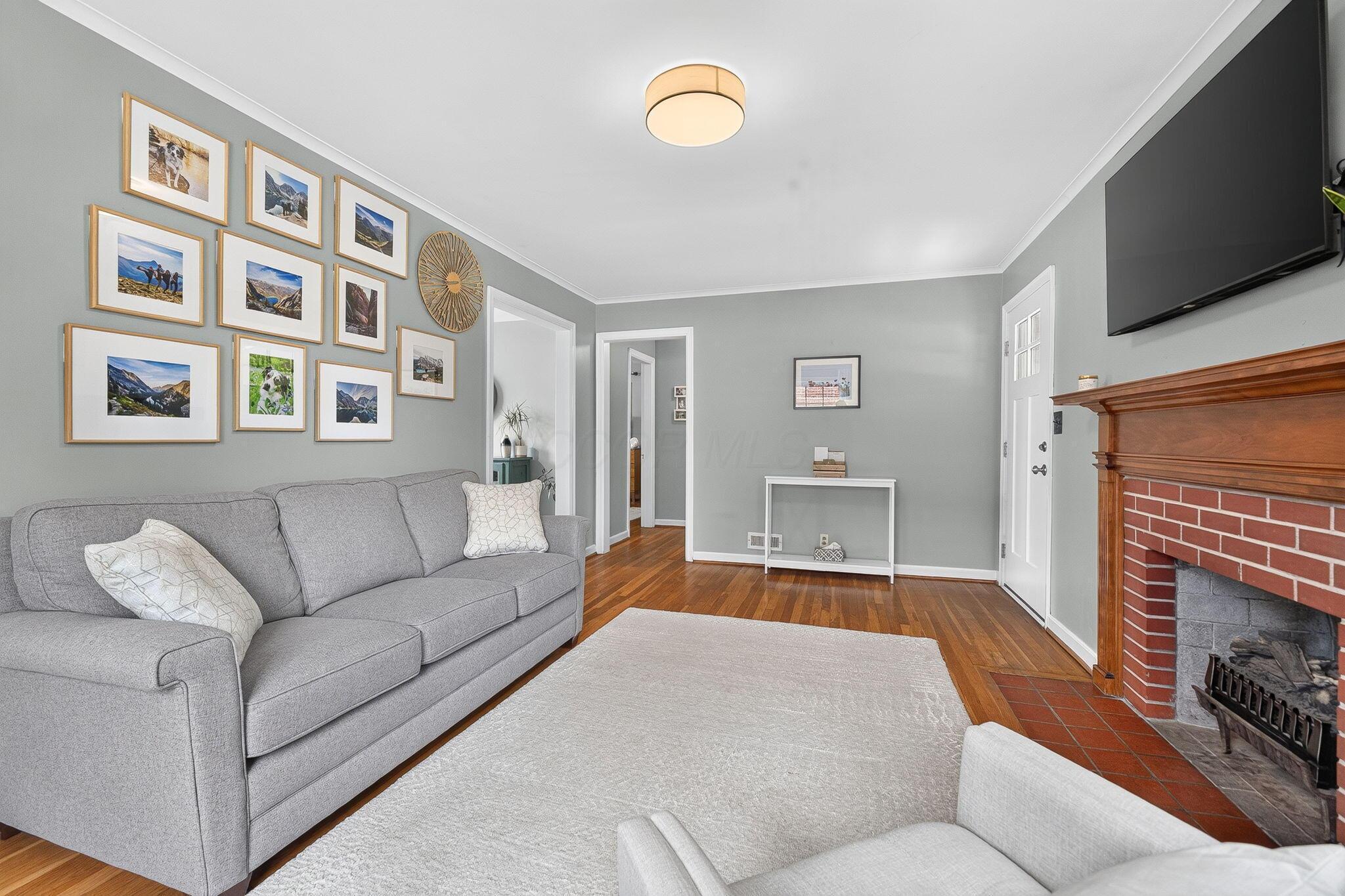 492 Wetmore Road Columbus, OH 43214 - Photo 16 of 55 Living area with wood-finish flooring, light gray wall paint, and white crown molding