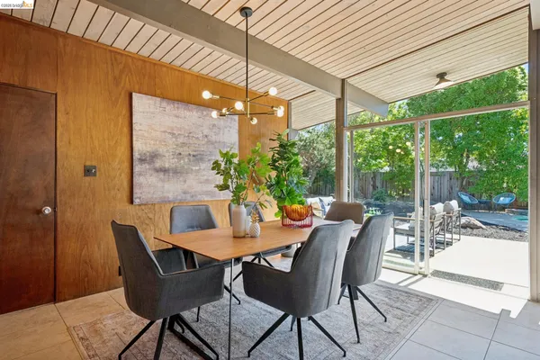 a kitchen with kitchen island granite countertop a table chairs sink and cabinets