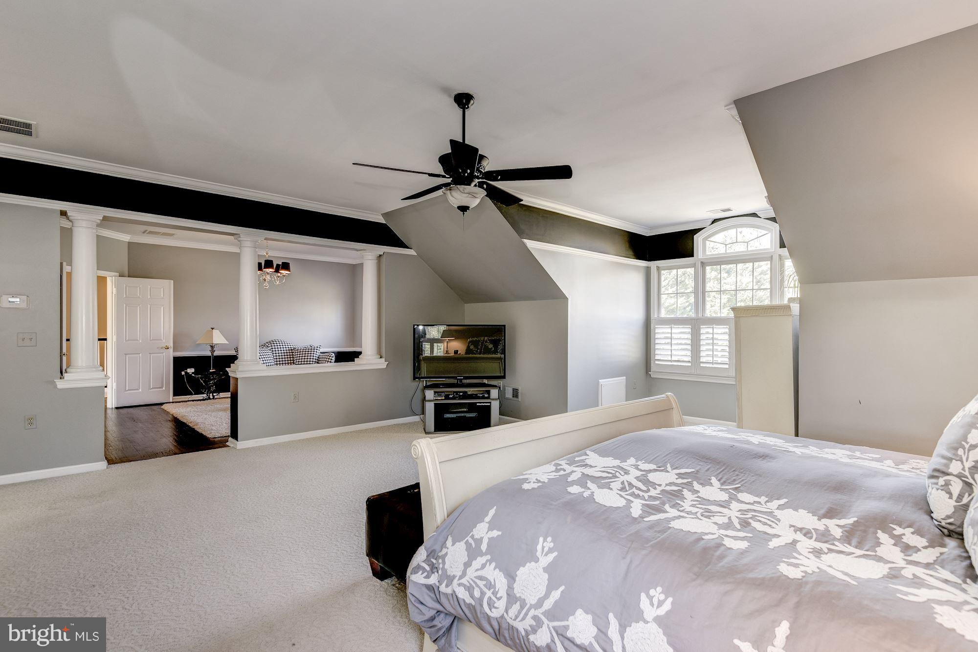 7730 Greentree Road Bethesda, MD 20817 - Photo 14 of 30 a large bedroom with a large bed and a chandelier