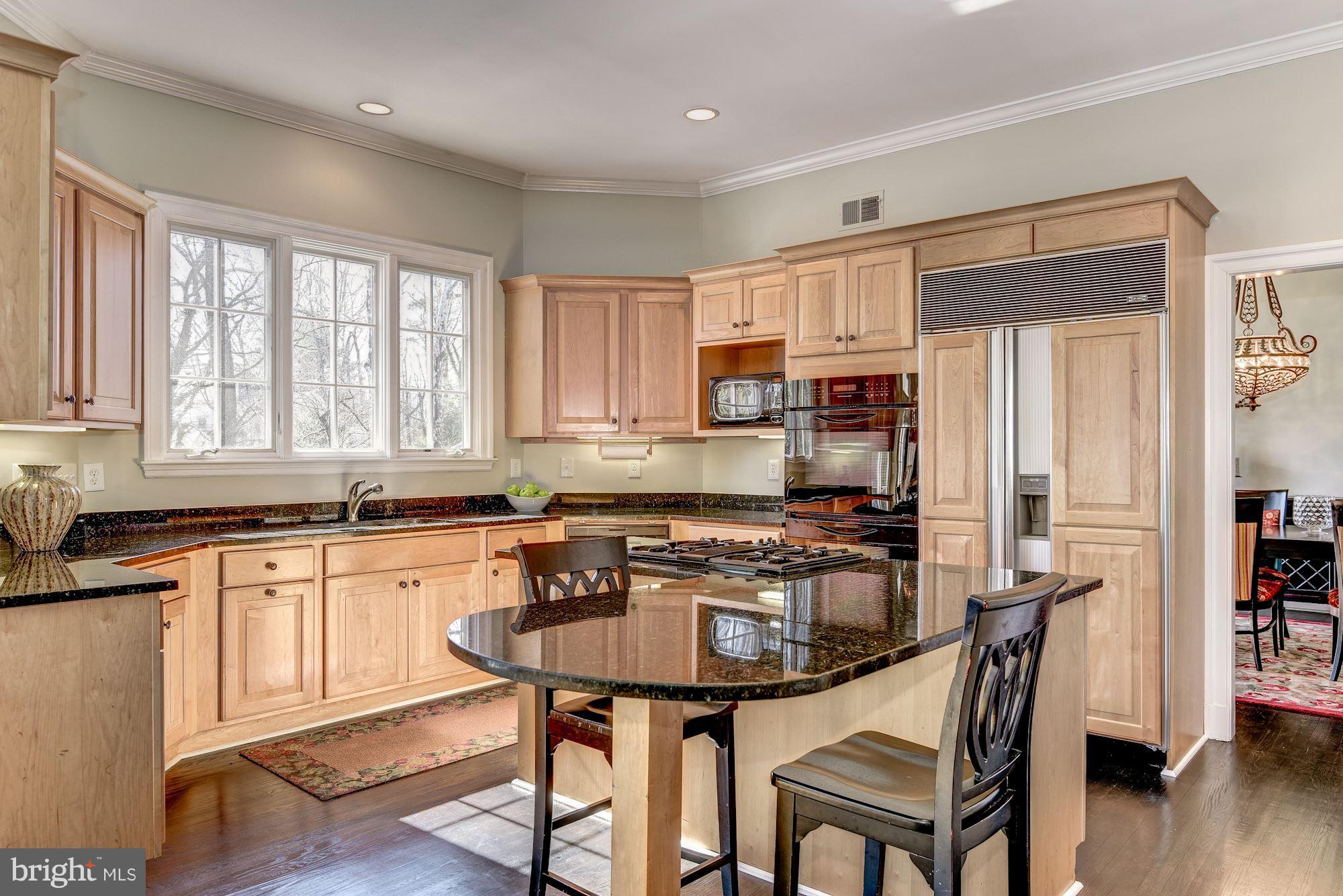 7730 Greentree Road Bethesda, MD 20817 - Photo 8 of 30 a kitchen with granite countertop a table chairs microwave and cabinets