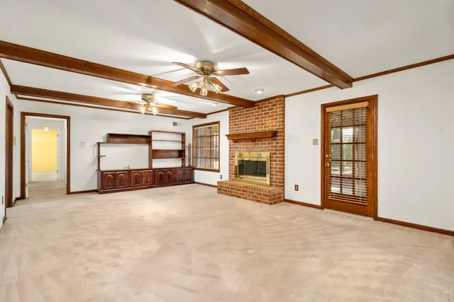 a view of an empty room with a fireplace and a window