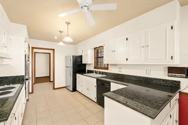 a kitchen with granite countertop a sink a counter top space appliances and cabinets