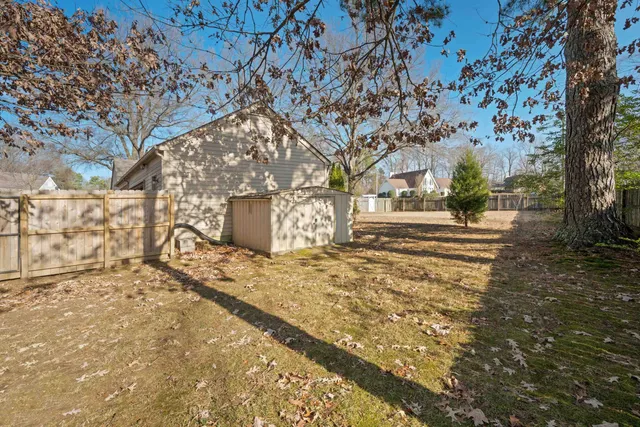 a view of a yard with wooden fence