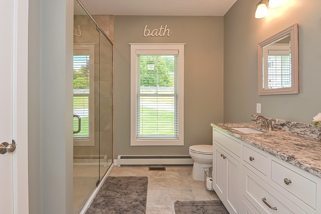 128 Nourse Road Bolton, MA 01740 - Photo 19 of 42 a bathroom with a granite countertop toilet a sink and a window