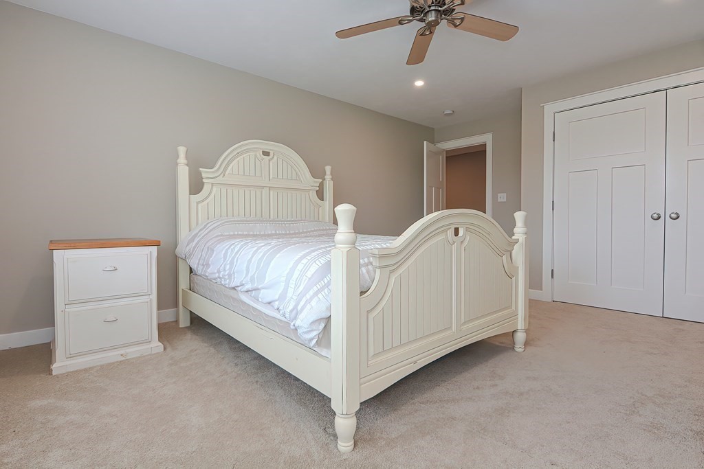 128 Nourse Road Bolton, MA 01740 - Photo 26 of 42 a bed room with a bed and a chandelier