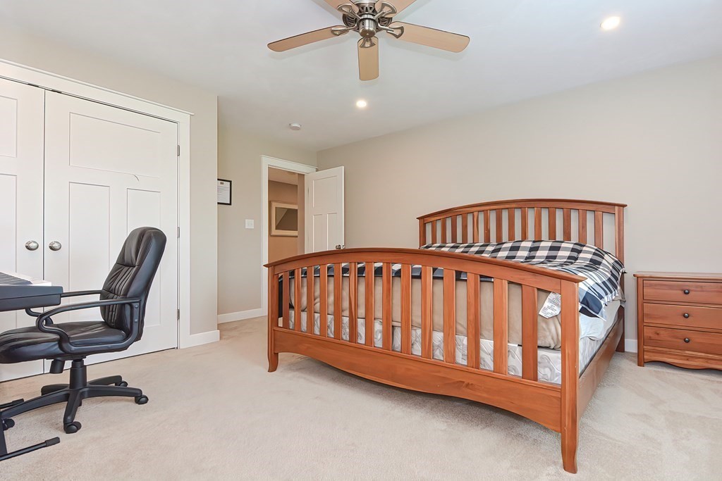 128 Nourse Road Bolton, MA 01740 - Photo 28 of 42 a bedroom with a bed and a chandelier