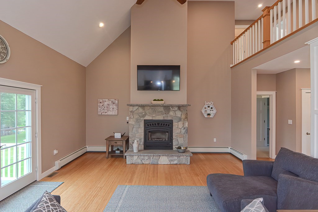 128 Nourse Road Bolton, MA 01740 - Photo 6 of 42 a living room with furniture a flat screen tv and a fireplace