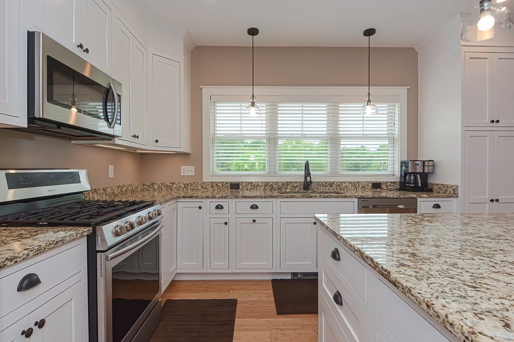 128 Nourse Road Bolton, MA 01740 - Photo 8 of 42 a kitchen with stainless steel appliances granite countertop a sink stove and microwave