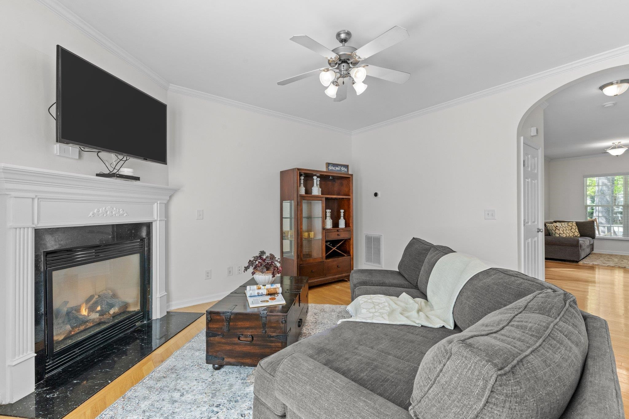 8411 Tie Stone Way Raleigh, NC 27613 - Photo 11 of 38 a living room with furniture a flat screen tv and a fireplace