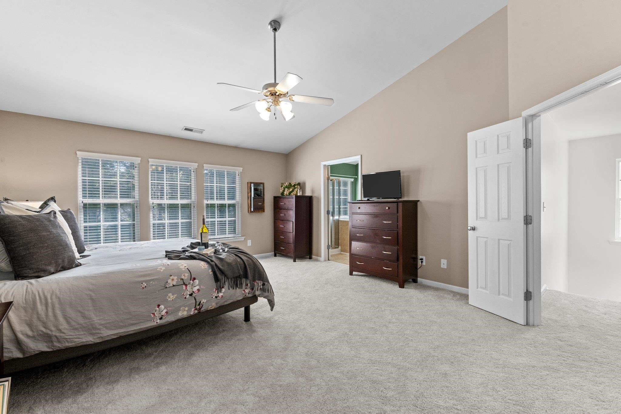 8411 Tie Stone Way Raleigh, NC 27613 - Photo 22 of 38 a spacious bedroom with a bed flat screen tv and a large window