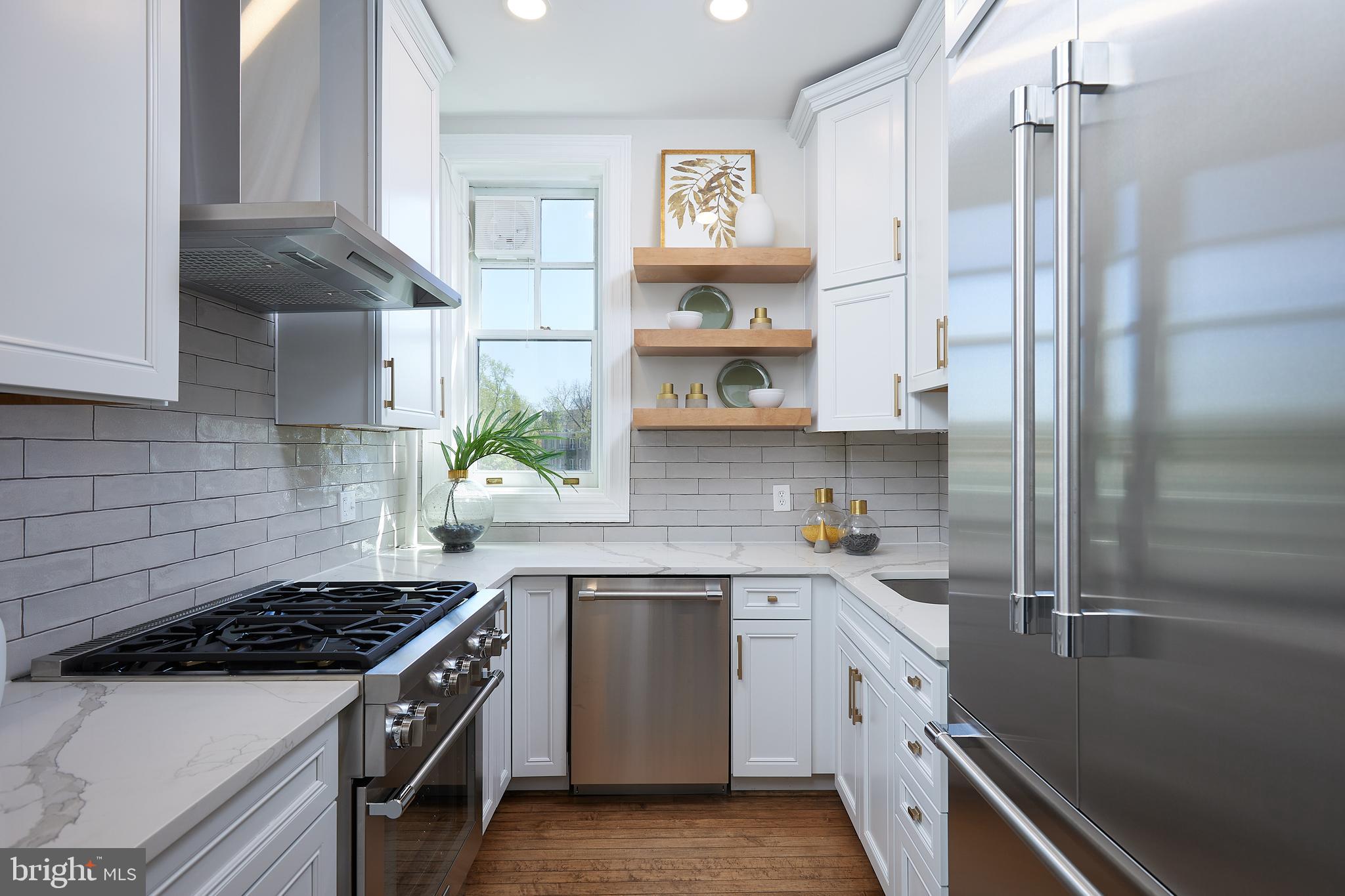 2853 Ontario Road Northwest, Unit 323 Washington, DC 20009 - Photo 27 of 66 a kitchen with stainless steel appliances a sink stove and refrigerator
