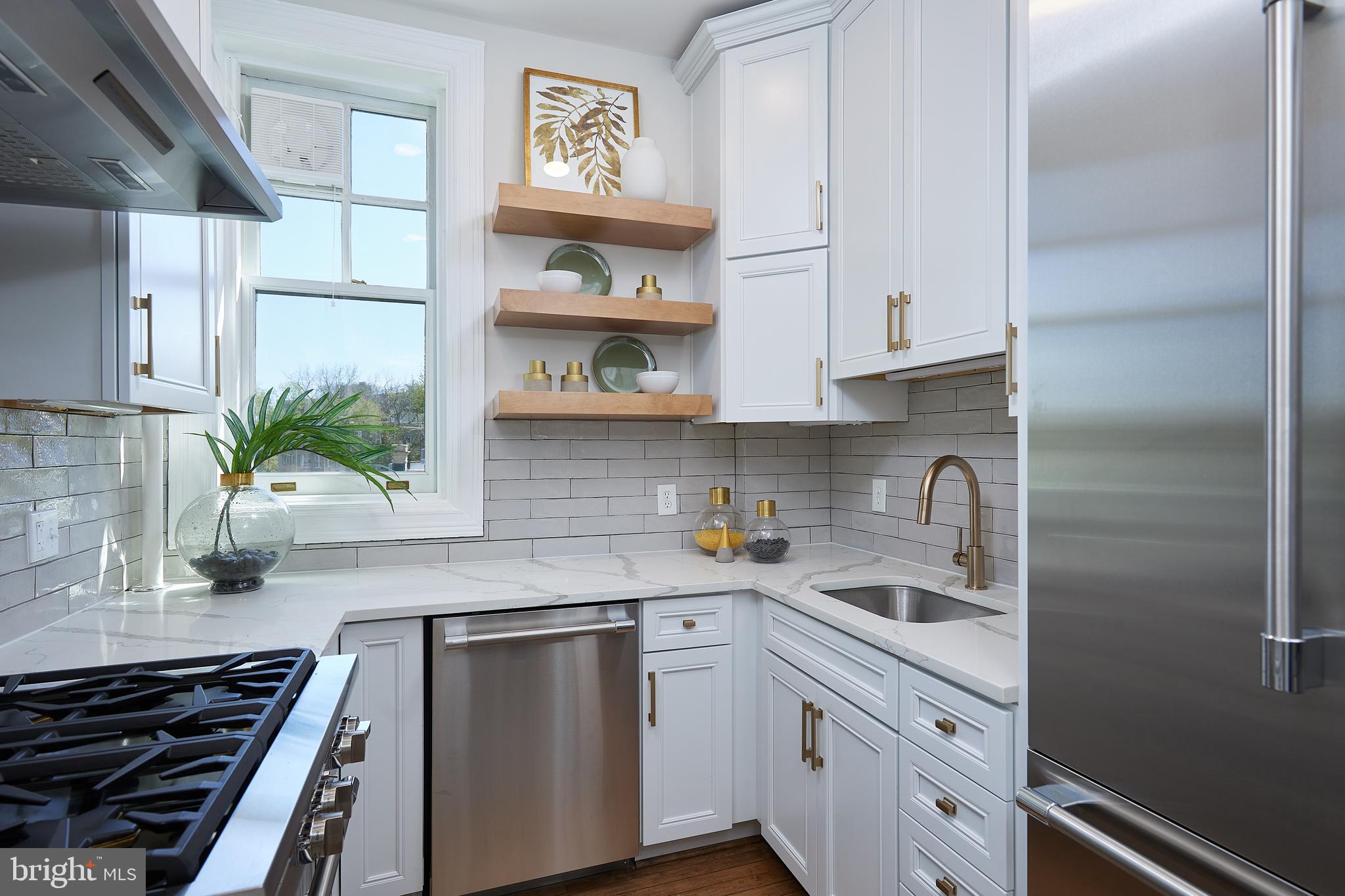 2853 Ontario Road Northwest, Unit 323 Washington, DC 20009 - Photo 28 of 66 a kitchen with stainless steel appliances a sink stove and cabinets