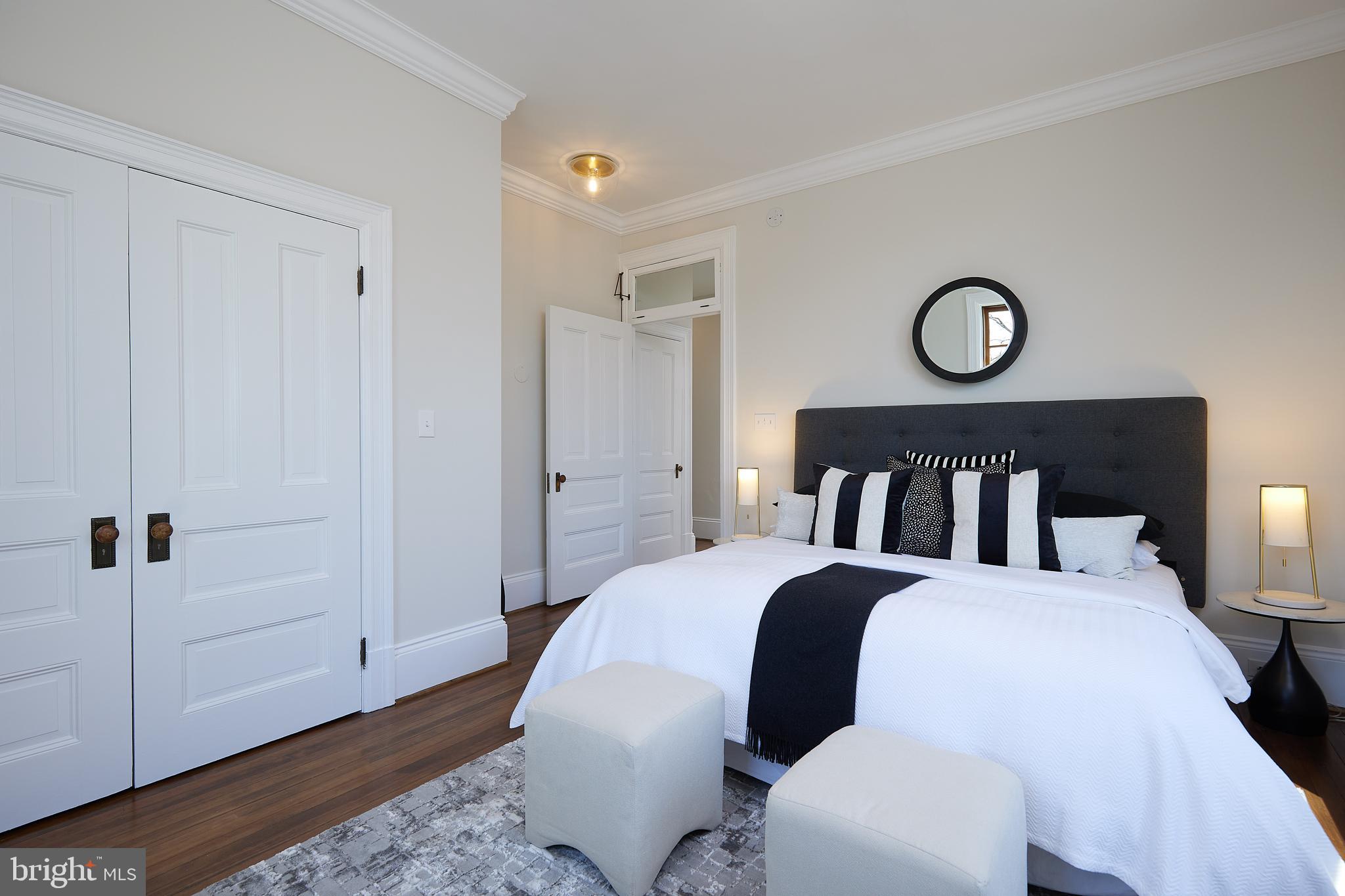 2853 Ontario Road Northwest, Unit 323 Washington, DC 20009 - Photo 34 of 66 a bedroom with a bed and wooden floor