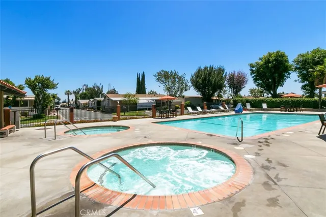 a view of a swimming pool with lawn chairs and potted plants