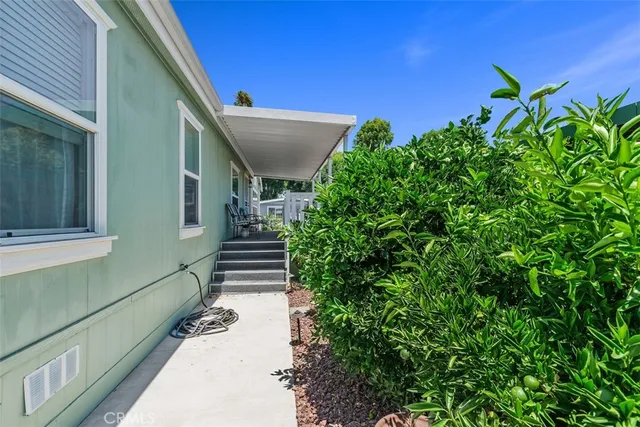 a view of a pathway of a house with potted plants