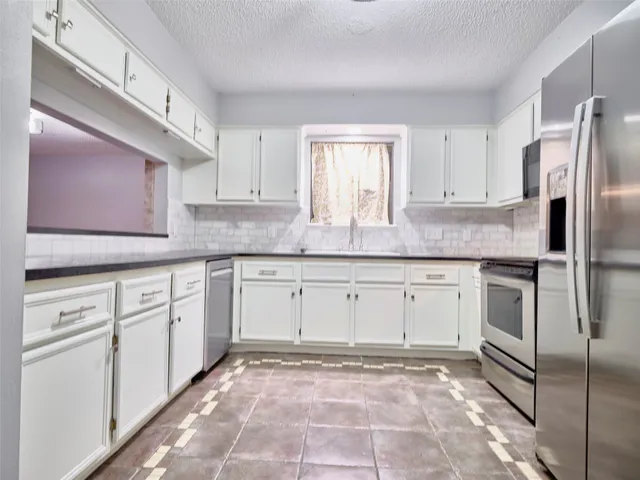 a kitchen with cabinets stainless steel appliances and a sink