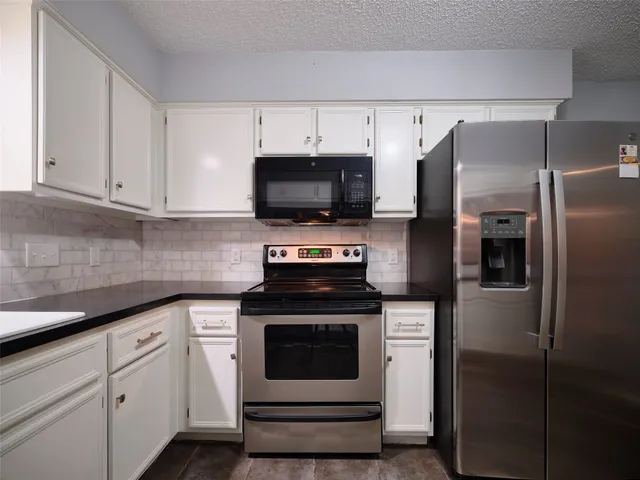 a spacious bathroom with a granite countertop sink and a mirror