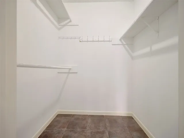 a view of an empty room with chandelier fan