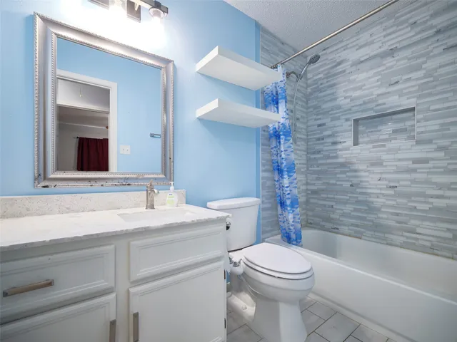 a bathroom with a granite countertop sink a toilet and mirror