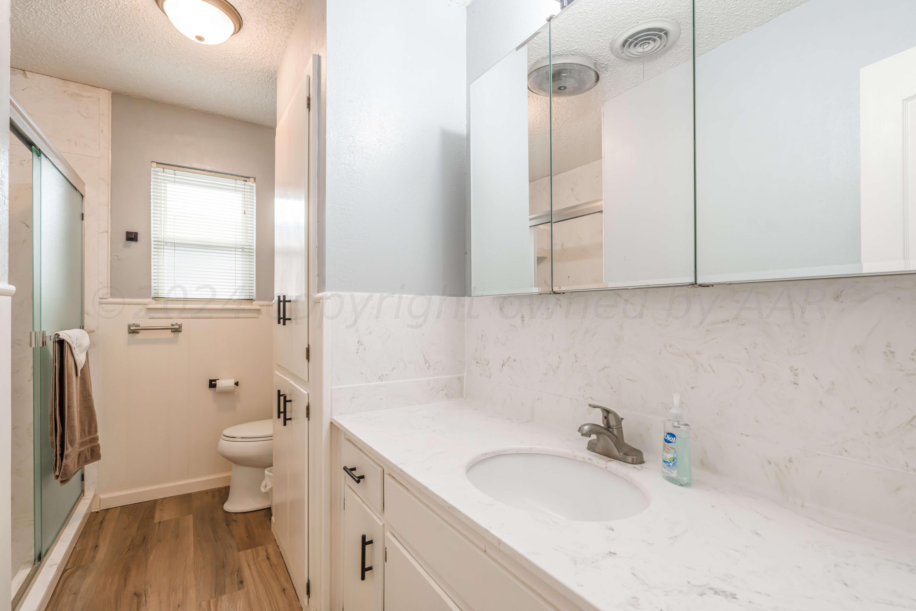 4513 Mesa Circle Amarillo, TX 79109 - Photo 15 of 18 a bathroom with a granite countertop sink toilet and shower curtains