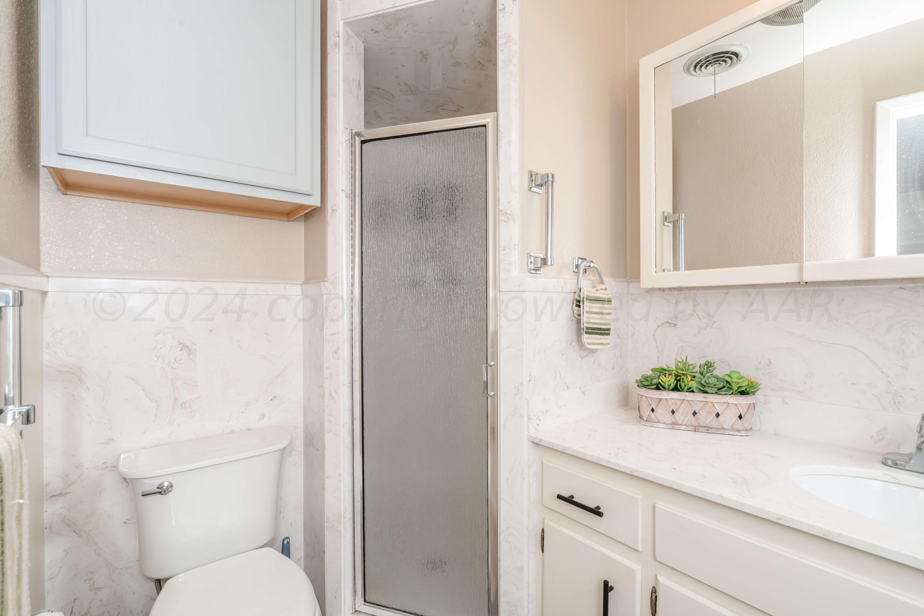 4513 Mesa Circle Amarillo, TX 79109 - Photo 4 of 18 a bathroom with a sink a toilet and shower