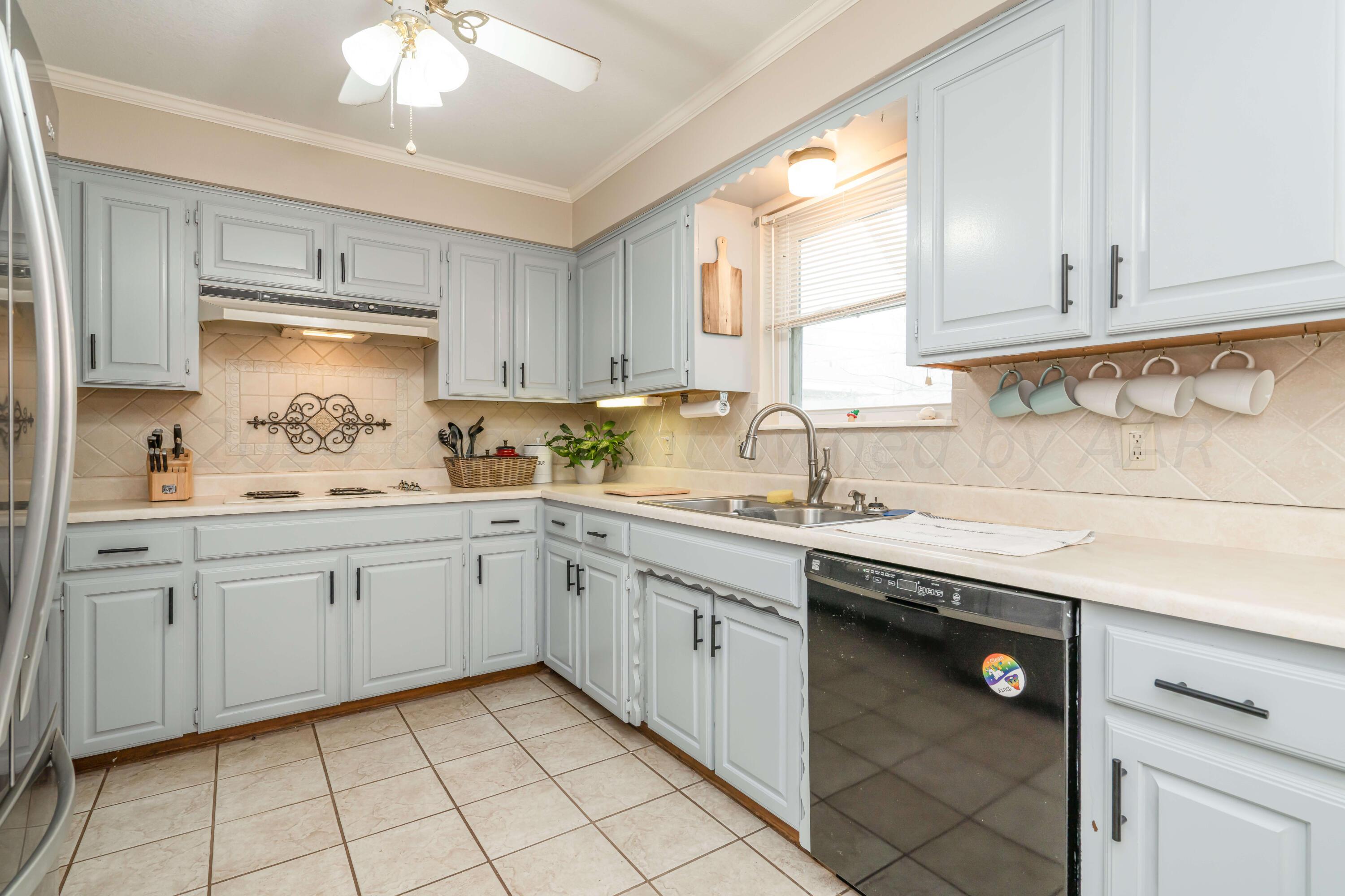 4513 Mesa Circle Amarillo, TX 79109 - Photo 5 of 18 a kitchen with cabinets appliances a sink and a window