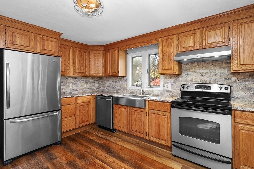 8 Autumn Lane Walpole, MA 02081 - Photo 5 of 28 a kitchen with granite countertop stainless steel appliances a refrigerator a stove a sink cabinets and a window