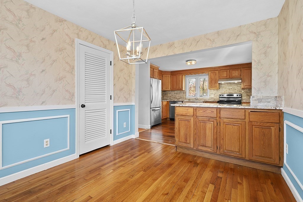 8 Autumn Lane Walpole, MA 02081 - Photo 8 of 28 a kitchen with stainless steel appliances granite countertop a refrigerator a sink dishwasher a stove and white cabinets with wooden floor