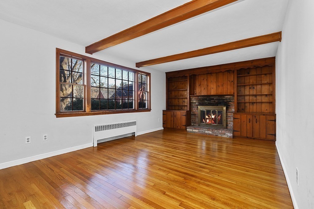 8 Autumn Lane Walpole, MA 02081 - Photo 9 of 28 a view of empty room with wooden floor and fireplace