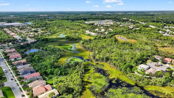 an aerial view of residential houses with outdoor space and trees