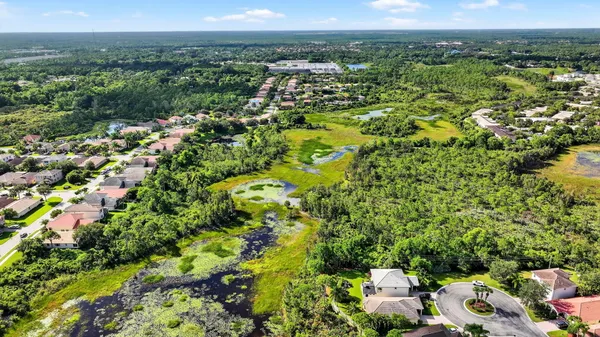 an aerial view of residential houses with outdoor space and trees