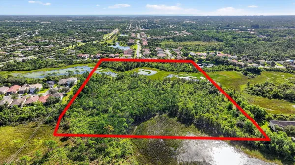 an aerial view of residential houses with outdoor space and trees