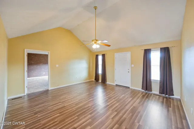 a view of a room with wooden floor and a window