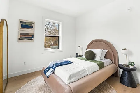 a bedroom with a bed and a large window