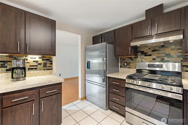 a kitchen with stainless steel appliances granite countertop a refrigerator and a sink