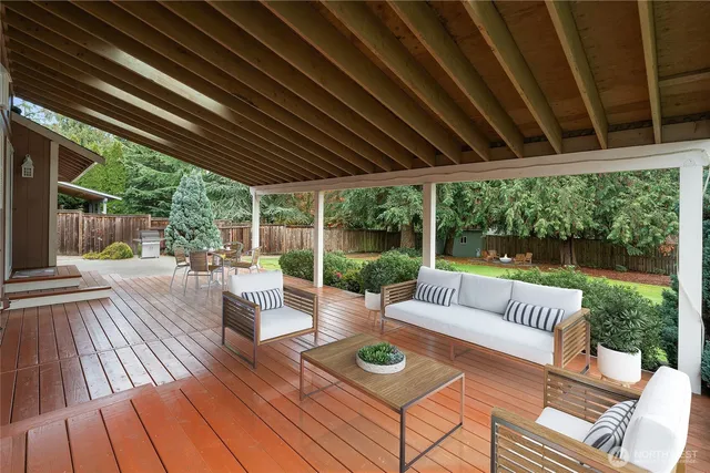 a view of a patio with couches potted plants and wooden floor
